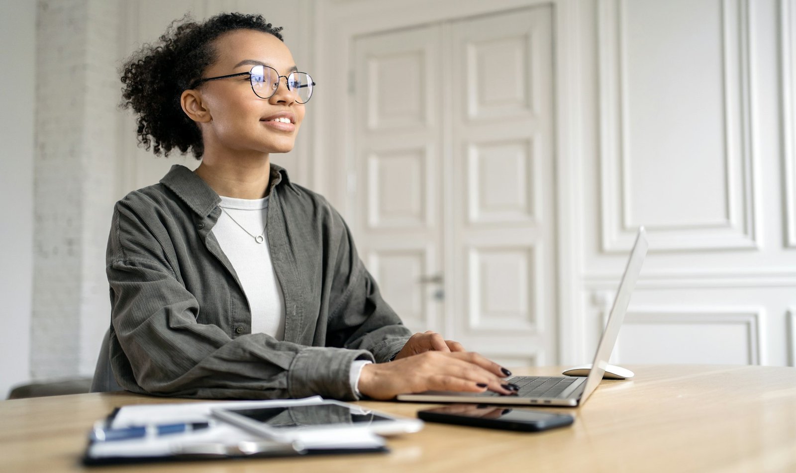 A female programmer with glasses is working on a project online.